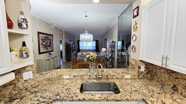 9587 Weldon Cir Unit B414, Tamarac, FL 33321 - kitchen featuring a sink, crown molding, tasteful backsplash, a chandelier, and light stone countertops