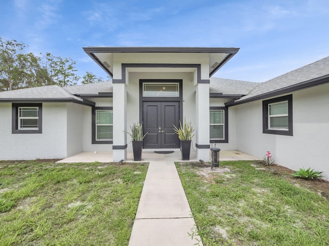 16430 71st Ln N, Loxahatchee, FL 33470 - doorway to property featuring roof with shingles, stucco siding, and a yard