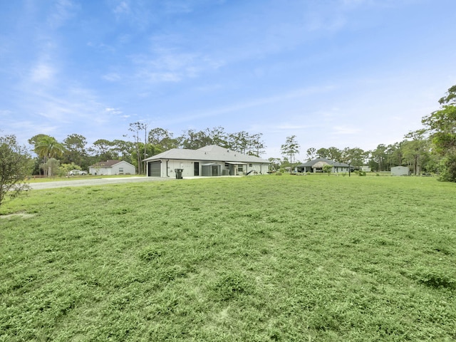 16430 71st Ln N, Loxahatchee, FL 33470 - view of green lawn with a garage and driveway