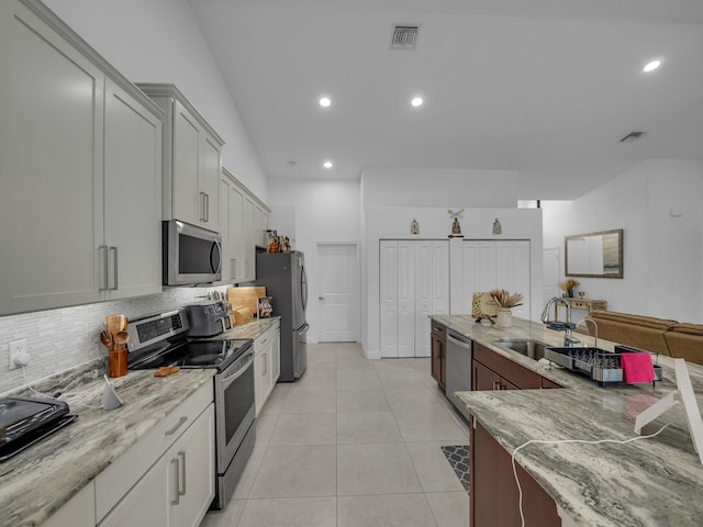 16430 71st Ln N, Loxahatchee, FL 33470 - kitchen with stainless steel appliances, a sink, backsplash, light stone counters, and recessed lighting