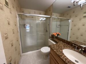 18856 Argosy Dr Unit C, Boca Raton, FL 33496 - bathroom with wallpapered walls, vanity, a stall shower, toilet, and tile patterned floors