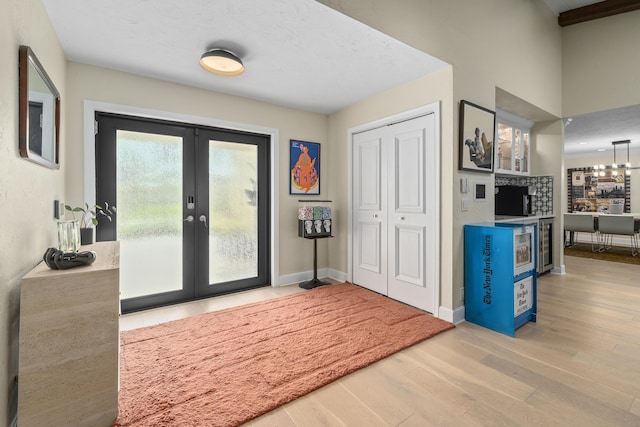 2407 SW 23rd Cranbrook Dr, Boynton Beach, FL 33436 - entryway featuring wood finished floors, french doors, baseboards, and wine cooler