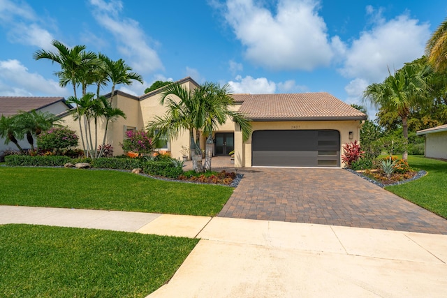 2407 SW 23rd Cranbrook Dr, Boynton Beach, FL 33436 - mediterranean / spanish-style home with decorative driveway, stucco siding, a front yard, a tile roof, and a garage