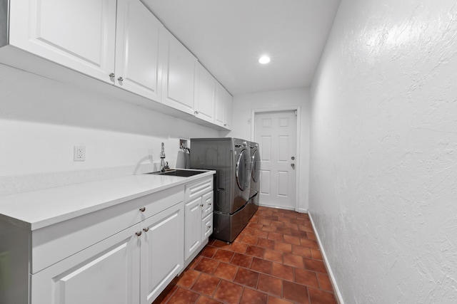 2407 SW 23rd Cranbrook Dr, Boynton Beach, FL 33436 - washroom featuring separate washer and dryer, a textured wall, cabinet space, baseboards, and dark tile patterned floors