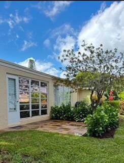 13725 Flora Pl Unit D, Delray Beach, FL 33484 - rear view of house featuring a lawn and stucco siding