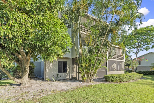 800 NW Fork Rd Unit 9-1, Stuart, FL 34994 - view of side of home featuring stucco siding, a lawn, and a sunroom