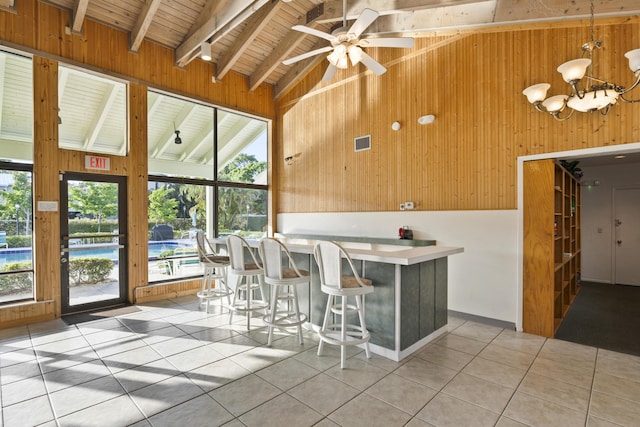 800 NW Fork Rd Unit 9-1, Stuart, FL 34994 - kitchen featuring wood ceiling with exposed beams, wood walls, light tile patterned flooring, plenty of natural light, and a ceiling fan