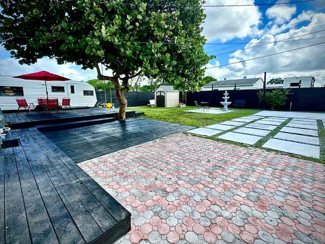 5690 Honeysuckle Dr, West Palm Beach, FL 33415 - fenced backyard featuring a wooden deck, a patio, and outdoor dining space