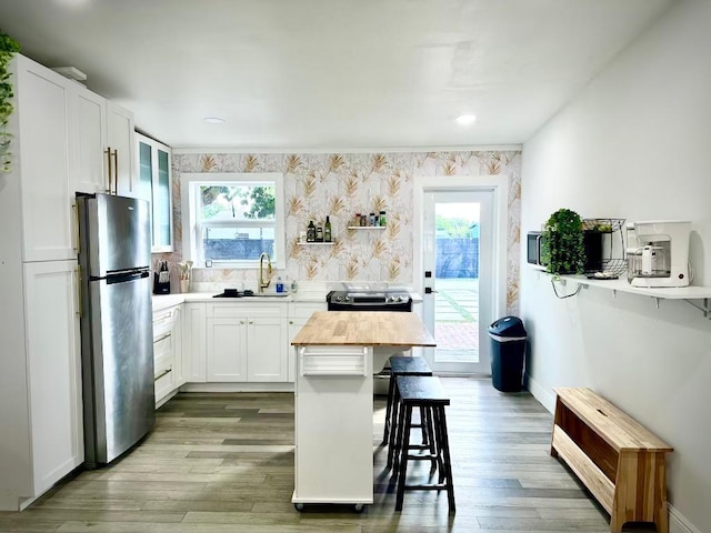 5690 Honeysuckle Dr, West Palm Beach, FL 33415 - kitchen with freestanding refrigerator, a sink, stove, wooden counters, and a kitchen breakfast bar