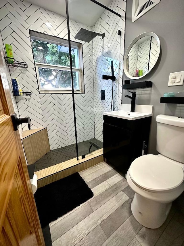 5690 Honeysuckle Dr, West Palm Beach, FL 33415 - full bathroom featuring vanity, a walk in shower, wood-type flooring, and toilet