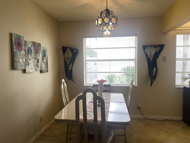 173 Normandy D, Delray Beach, FL 33484 - dining space featuring a textured ceiling, tile patterned flooring, and a chandelier