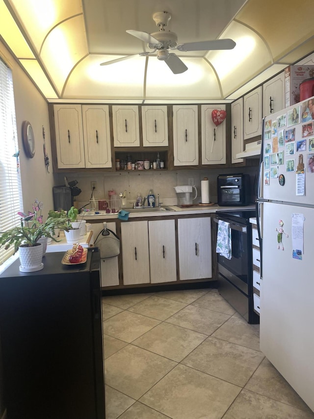 173 Normandy D, Delray Beach, FL 33484 - kitchen featuring freestanding refrigerator, electric stove, light tile patterned floors, ceiling fan, and under cabinet range hood