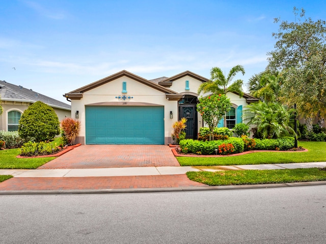 11187 SW Lake Park Dr, Port Saint Lucie, FL 34987 - view of front facade featuring decorative driveway, stucco siding, and an attached garage