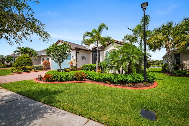 11187 SW Lake Park Dr, Port Saint Lucie, FL 34987 - view of front of property featuring stucco siding, a garage, a front lawn, and driveway