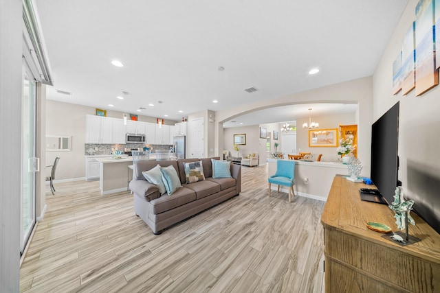 11187 SW Lake Park Dr, Port Saint Lucie, FL 34987 - living area featuring arched walkways, a chandelier, light wood-type flooring, recessed lighting, and baseboards