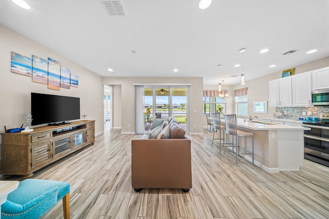 11187 SW Lake Park Dr, Port Saint Lucie, FL 34987 - living room featuring light wood-style floors, baseboards, and recessed lighting