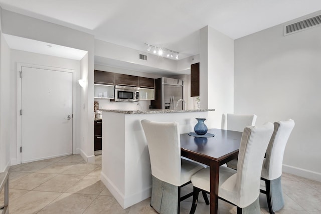 550 Okeechobee Blvd Unit 504, West Palm Beach, FL 33401 - dining space with rail lighting, light tile patterned floors, and baseboards