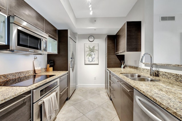 550 Okeechobee Blvd Unit 504, West Palm Beach, FL 33401 - kitchen with stainless steel appliances, a sink, dark brown cabinets, light tile patterned floors, and modern cabinets