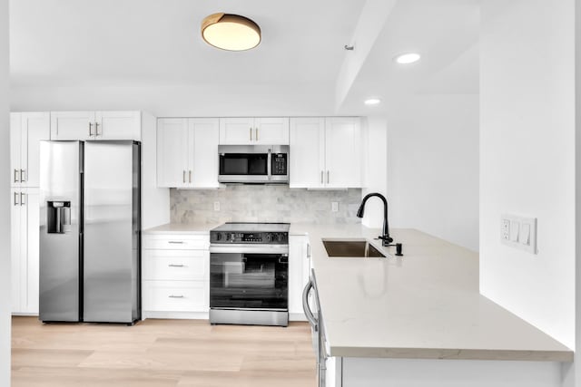 7076 Huntington Ln Unit 206, Delray Beach, FL 33446 - kitchen featuring stainless steel appliances, recessed lighting, white cabinets, backsplash, and light wood-style floors