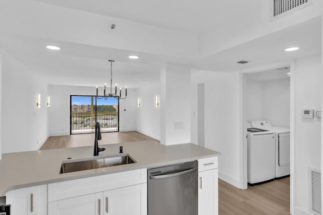 7076 Huntington Ln Unit 206, Delray Beach, FL 33446 - kitchen with stainless steel dishwasher, washing machine and clothes dryer, light wood-type flooring, white cabinetry, and light countertops
