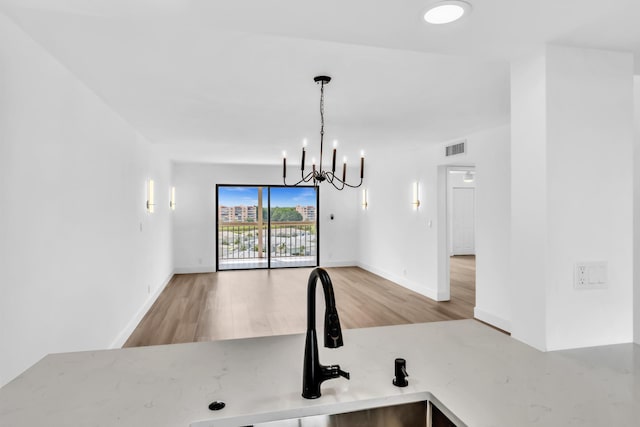 7076 Huntington Ln Unit 206, Delray Beach, FL 33446 - kitchen with wood finished floors, a chandelier, and light countertops
