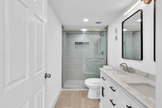 7076 Huntington Ln Unit 206, Delray Beach, FL 33446 - bathroom with double vanity, a shower stall, wood finished floors, and recessed lighting