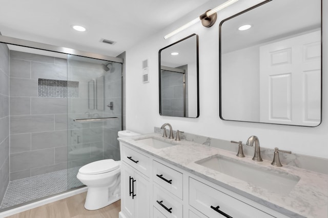 7076 Huntington Ln Unit 206, Delray Beach, FL 33446 - bathroom featuring a tile shower, double vanity, recessed lighting, and wood finished floors