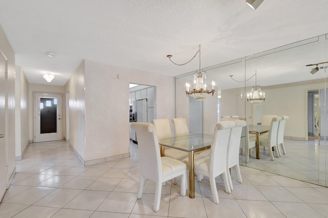5800 Fernley Dr W Unit 51, Greenacres, FL 33415 - dining area with a chandelier, light tile patterned flooring, baseboards, and a textured ceiling