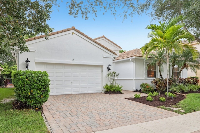 139 Sedona Way, Palm Beach Gardens, FL 33418 - view of front of property with a tile roof, an attached garage, decorative driveway, and stucco siding