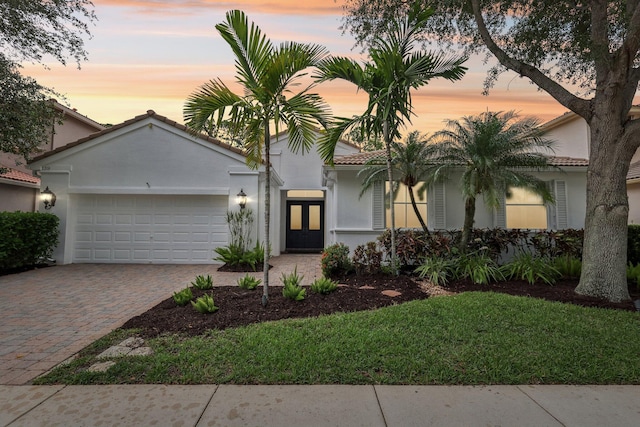 139 Sedona Way, Palm Beach Gardens, FL 33418 - view of front of property featuring a garage, decorative driveway, a tiled roof, stucco siding, and a front lawn