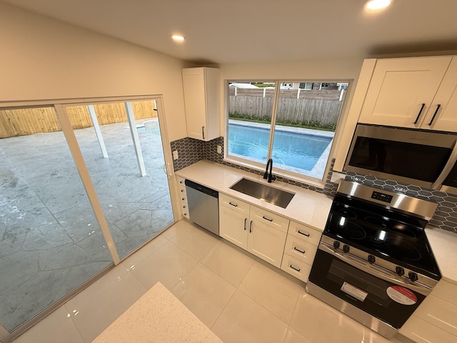 345 Pinehurst Rd, Palm Springs, FL 33461 - kitchen featuring stainless steel appliances, a sink, backsplash, white cabinetry, and recessed lighting