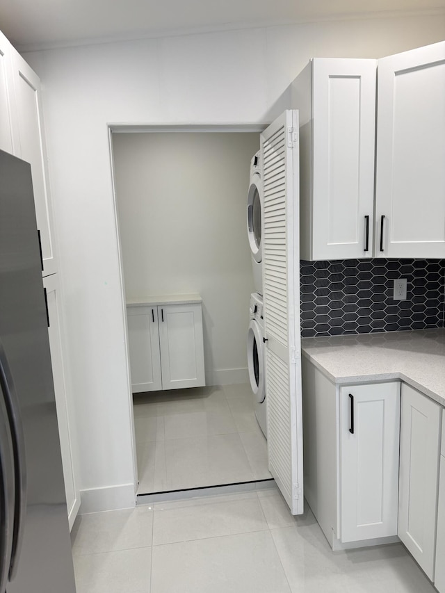 345 Pinehurst Rd, Palm Springs, FL 33461 - washroom with stacked washer / dryer, light tile patterned floors, and baseboards