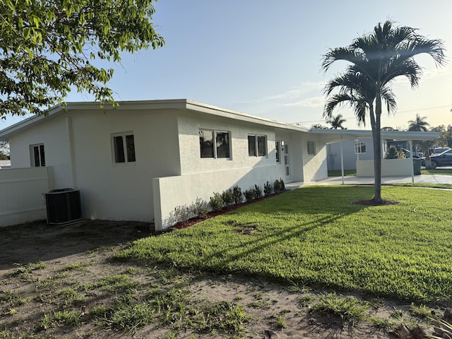 345 Pinehurst Rd, Palm Springs, FL 33461 - rear view of house with stucco siding, cooling unit, and an attached carport