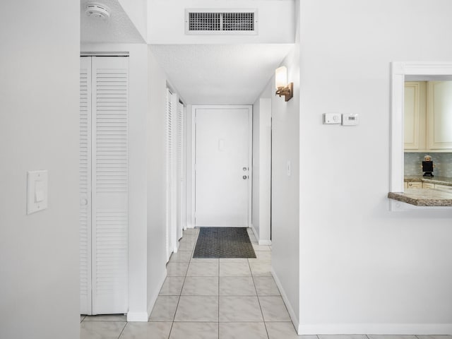715 Lori Dr Unit 213, Palm Springs, FL 33461 - corridor featuring baseboards, light tile patterned flooring, and a textured ceiling