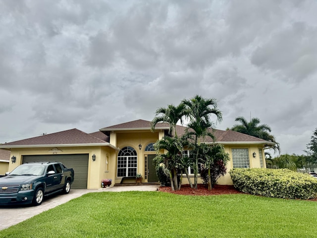 473 SW Dagget Ave, Port Saint Lucie, FL 34953 - view of front of property featuring stucco siding, a front lawn, an attached garage, and driveway