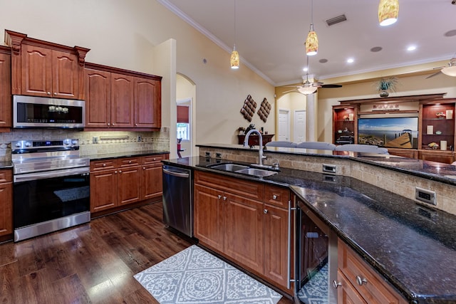 473 SW Dagget Ave, Port Saint Lucie, FL 34953 - kitchen with appliances with stainless steel finishes, a ceiling fan, arched walkways, a sink, and ornamental molding