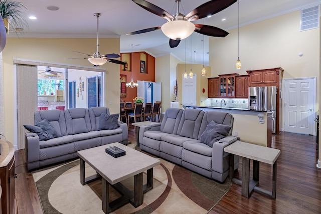 473 SW Dagget Ave, Port Saint Lucie, FL 34953 - living area with a ceiling fan, a chandelier, dark wood finished floors, ornamental molding, and high vaulted ceiling