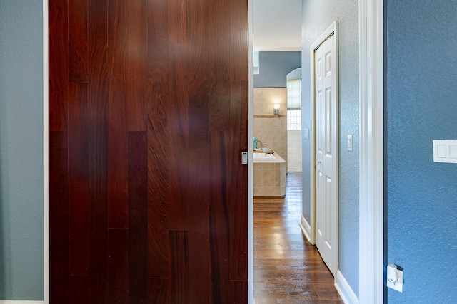 473 SW Dagget Ave, Port Saint Lucie, FL 34953 - hallway featuring dark wood-type flooring, a textured wall, and baseboards