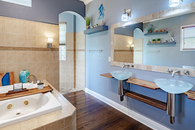 473 SW Dagget Ave, Port Saint Lucie, FL 34953 - full bathroom featuring a tub with jets, walk in shower, and wood finished floors