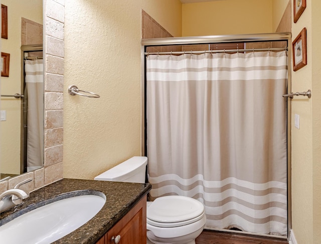 473 SW Dagget Ave, Port Saint Lucie, FL 34953 - bathroom featuring vanity, toilet, a textured wall, a shower with curtain, and wood finished floors