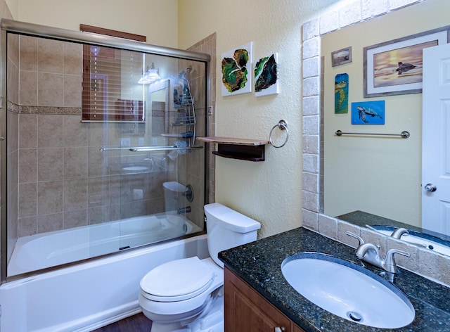 473 SW Dagget Ave, Port Saint Lucie, FL 34953 - bathroom with a textured wall, vanity, toilet, and combined bath / shower with glass door
