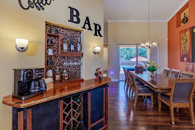 473 SW Dagget Ave, Port Saint Lucie, FL 34953 - dining room with dark wood finished floors, a bar, ornamental molding, and a chandelier