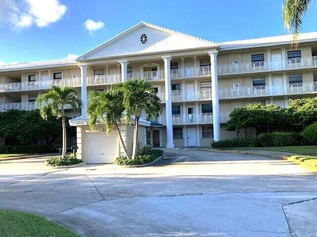 3507 Village Blvd Unit 401, West Palm Beach, FL 33409 - view of apartment building / complex with a garage and concrete driveway