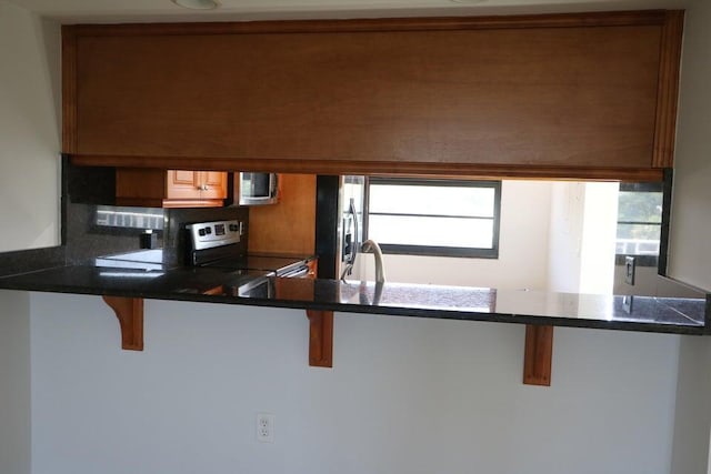 3507 Village Blvd Unit 401, West Palm Beach, FL 33409 - kitchen featuring appliances with stainless steel finishes, plenty of natural light, and a kitchen breakfast bar