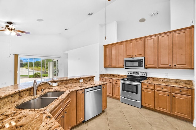 3024 Constellation Dr, Melbourne, FL 32940 - kitchen featuring appliances with stainless steel finishes, a ceiling fan, high vaulted ceiling, light tile patterned floors, and light stone counters