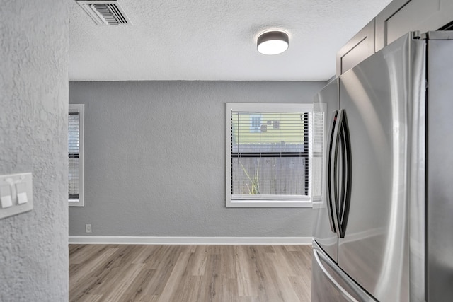 220 Walton Blvd, West Palm Beach, FL 33405 - kitchen featuring freestanding refrigerator, a textured wall, light wood-style flooring, a textured ceiling, and baseboards