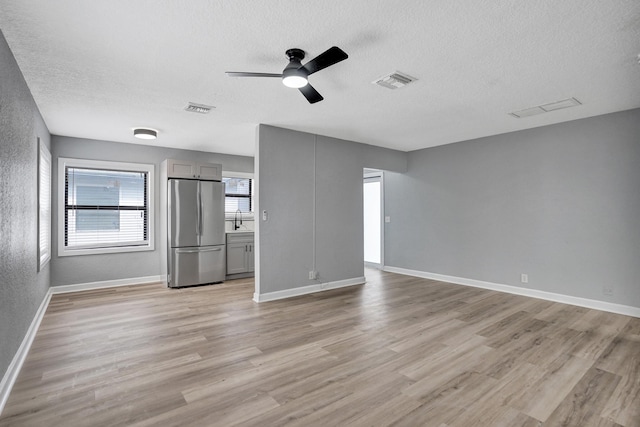 220 Walton Blvd, West Palm Beach, FL 33405 - unfurnished living room with a textured ceiling, a sink, light wood-style flooring, a ceiling fan, and baseboards