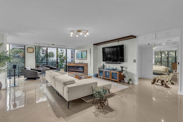 7572 Regency Lake Dr Unit 402, Boca Raton, FL 33433 - living room with light tile patterned flooring, plenty of natural light, a glass covered fireplace, and rail lighting