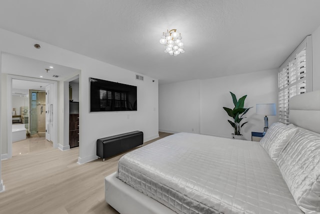 7572 Regency Lake Dr Unit 402, Boca Raton, FL 33433 - bedroom featuring light wood finished floors, baseboards, and a textured ceiling