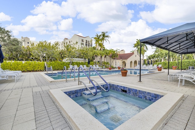 7572 Regency Lake Dr Unit 402, Boca Raton, FL 33433 - community pool featuring a community hot tub and a patio